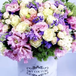 Large pastel bouquet of roses and purple blooms in a white hat box