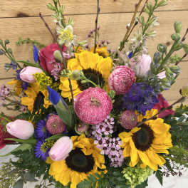 Mixed bouquet with sunflowers, pink tulips, and purple blooms
