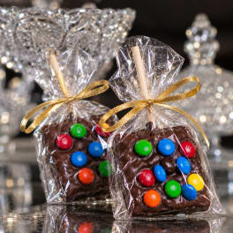 Wrapped chocolate treats topped with colorful candies and gold ribbons