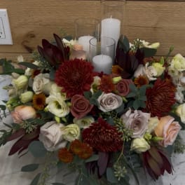 Low floral centerpiece with candles in glass cylinders