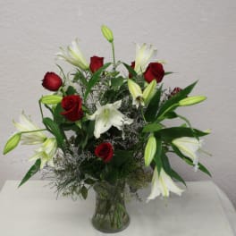 Red roses and white lilies in a clear glass vase
