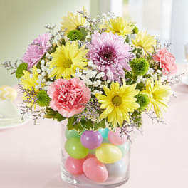 Mixed bouquet in a clear vase filled with pastel balloons