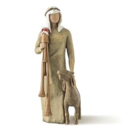 Carved figurine of a robed shepherd holding a staff beside a lamb