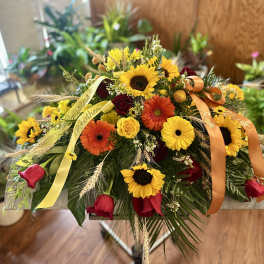 Mixed bouquet with sunflowers, gerbera daisies, and roses on a stand