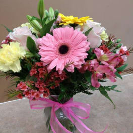 Mixed bouquet with pink gerbera daisies in a glass vase