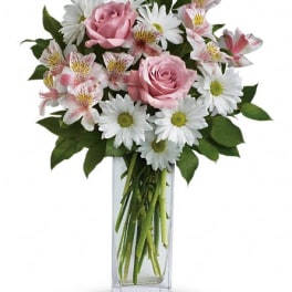 Pink roses and white daisies in a clear glass vase