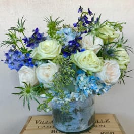 Blue and white floral arrangement in a glass vase