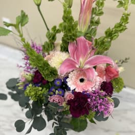 Pink lily and mixed flowers in a vase arrangement