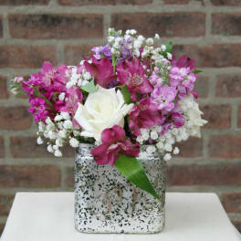 Pink and white flower arrangement in a silver square vase