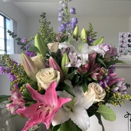 Large bouquet of lilies, roses, and purple flowers in a vase