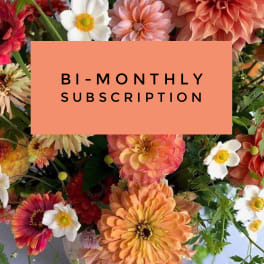 Mixed bouquet with peach, white, and red flowers around a subscription sign