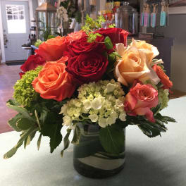 Mixed roses and hydrangeas arranged in a glass vase