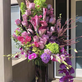 Tall bouquet of pink and purple flowers in a glass vase
