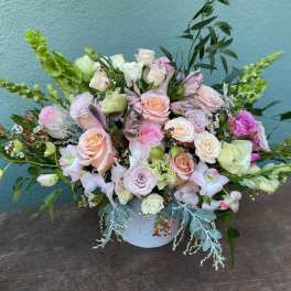 Pastel bouquet of roses and lisianthus in a white vase