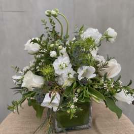 White floral arrangement in a square glass vase