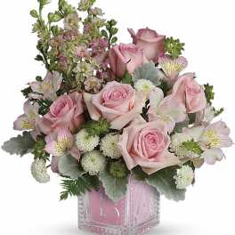 Pink roses and alstroemeria in a clear square vase
