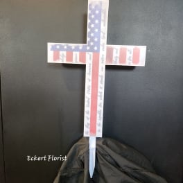 American flag cross-shaped memorial stake with a white base