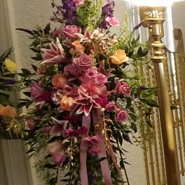 Tall floral spray with pink and purple flowers on a stand