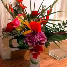 Colorful mixed bouquet in a glass vase with long leaves