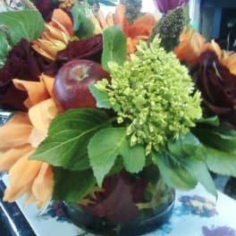 Autumn bouquet with orange and burgundy flowers in a glass vase