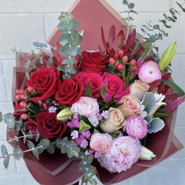 Bouquet of red and pink roses with pale blooms and eucalyptus