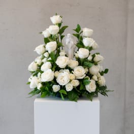 White rose arrangement with a small angel figurine in the center