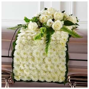 White rose and chrysanthemum floral arrangement on a casket