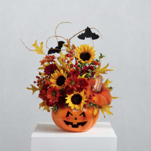 Halloween floral arrangement in a jack-o'-lantern pumpkin container