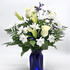 White flowers and pale yellow roses arranged in a blue vase