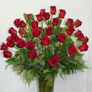 Red roses arranged in a clear glass vase