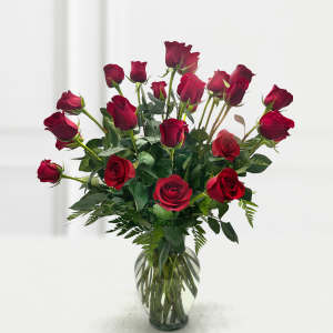 Red roses arranged in a clear glass vase