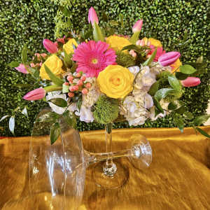 Pink and yellow flower arrangement in a clear glass vase