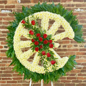 Large floral wreath with white flowers and red roses on a stand