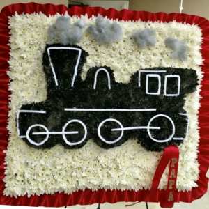 Floral tribute shaped like a train with a red ribbon border