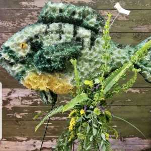 Large fish-shaped floral display with green, white, and yellow flowers