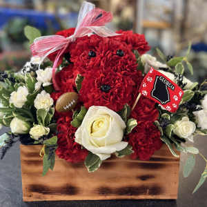 Red carnations and white roses in a wooden box with a ribbon and Georgia flag pick.