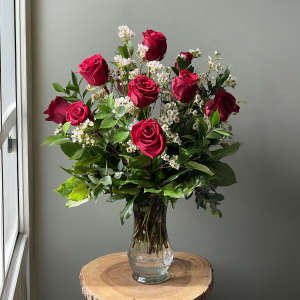 Bouquet of red roses and white filler flowers in a clear glass vase