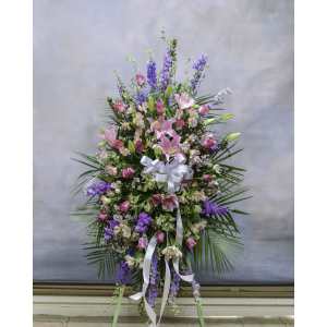 Tall standing floral spray with pink lilies and purple blooms, tied with white ribbon