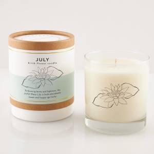 Two lily-themed candles, one in a labeled box and one in a glass jar