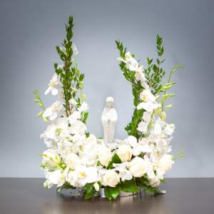 White floral arrangement with a small statue in the center