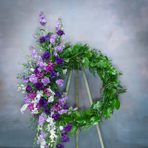 Purple and white floral wreath on a stand