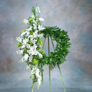 White floral funeral wreath on a standing easel