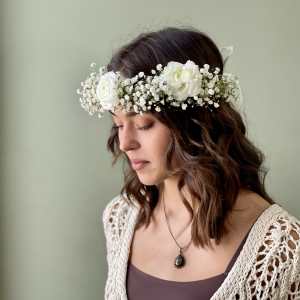 Woman wearing a white floral crown with small white blooms