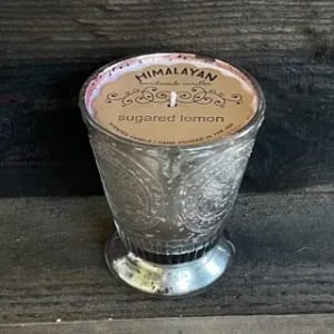 A glass candle in an embossed holder labeled sugared lemon