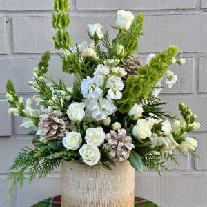 White roses and snapdragons in a beige textured vase