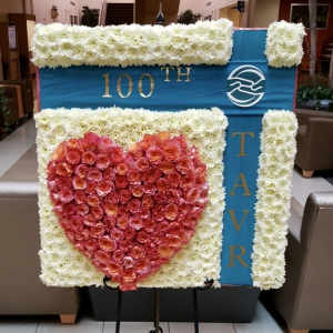 Large floral display with a red rose heart on a blue and white board