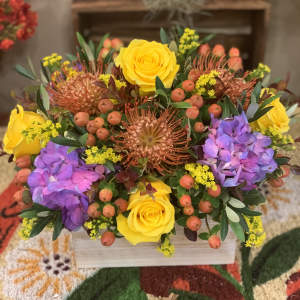 Bright mixed bouquet with yellow roses and purple hydrangeas in a wooden box