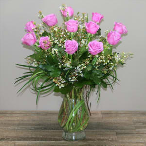 Pink roses arranged in a clear glass vase with small white filler flowers