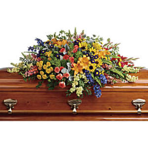 Colorful floral spray arranged on a wooden casket