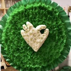 Large round floral wreath with white flowers on a green background